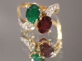 une image montrant un gros plan d'une bague en or sertie d'une pierre verte et rouge
