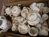 a box full of tea cups and saucers on the floor