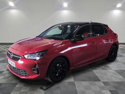 une voiture rouge garée dans un garage au sol en damier