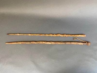 deux bâtonnets en bois munis d'un manche sont posés sur une surface grise