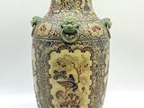 un grand vase orné d'un dragon, posé sur une table