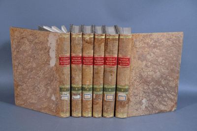 trois livres sont empilés les uns sur les autres sur une surface bleue