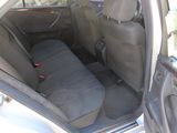 the back seat of a car with the door open and a seat belt down