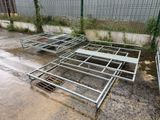 a metal bed frame laying on the ground next to a fence