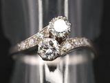 un gros plan d'une bague en diamant posée sur un présentoir en argent