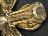 a close up of a gold brooch on a black surface