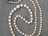 un gros plan d'un collier orné de perles sur un fond gris
