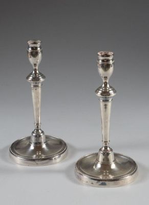 pair of silver candlesticks on a white background