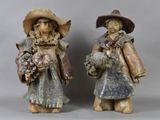 two figurines of two people with hats and holding flowers
