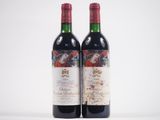 deux bouteilles de vin rouge posées l'une à côté de l'autre sur une surface blanche