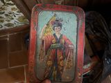 a person holding a small tray with a painting on it