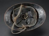 an old helmet with a leather strap on a black background