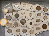 some old coins are sitting on top of a table next to each other