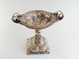 an antique silver plated bowl on a stand on a white background