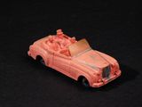 une petite voiture rose posée sur une surface noire