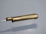 a small knife with a gold handle on a gray surface