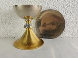 a gold chalicet and a mirror on a table