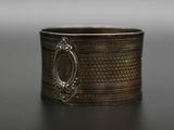 un gros plan d'une bague posée sur une table, sur fond gris