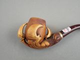 a wooden pipe with a carved animal on it on a table