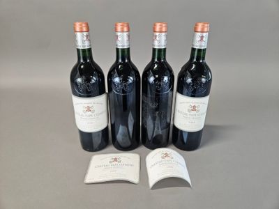 trois bouteilles de vin rouge posées sur une table, à côté d'un livre