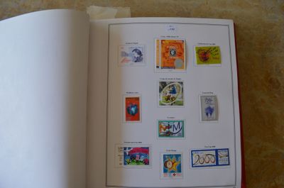 un livre ouvert avec des timbres, posé sur une table