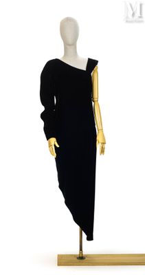 une photo d'un mannequin vêtu d'une robe noire, posé sur un socle en bois