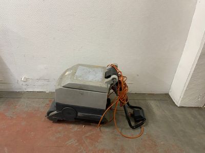 a machine that is sitting on the floor next to a wall