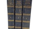 three old books sitting on top of each other on a white surface
