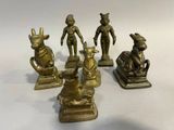 plusieurs figurines en laiton représentant des animaux et des personnages, posées sur une surface blanche