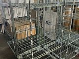 une grande cage métallique remplie de cartons dans un entrepôt