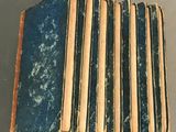 several old books are stacked on top of each other on a table