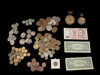 beaucoup de pièces de monnaie et une montre de poche sur la table