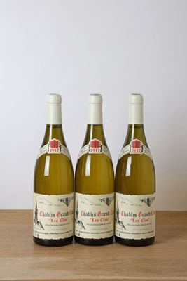 trois bouteilles de vin posées sur une table en bois, à côté d'une bouteille de vin