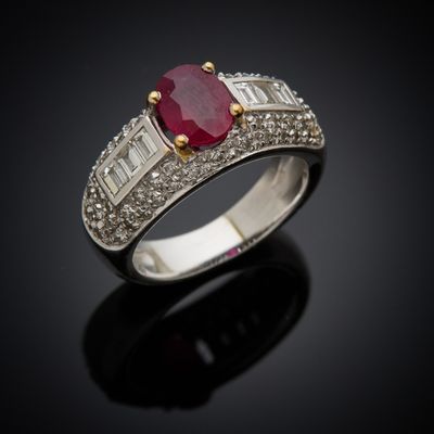 an oval ruby and diamond ring on a black surface