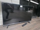 une télévision à écran plat posée sur une table devant un garage