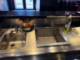 two sinks in a restaurant with a donut on the counter
