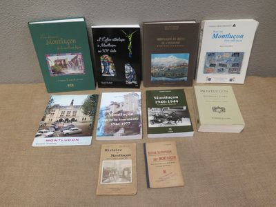 several books are sitting on a table in front of a wall
