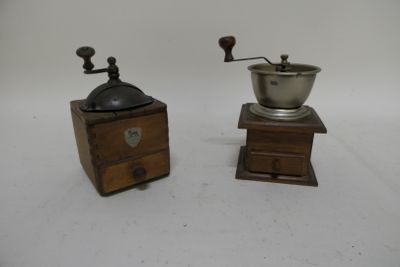 two old coffee grinders on a white surface