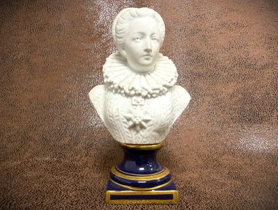 a white bust of a woman on a blue and gold pedestal