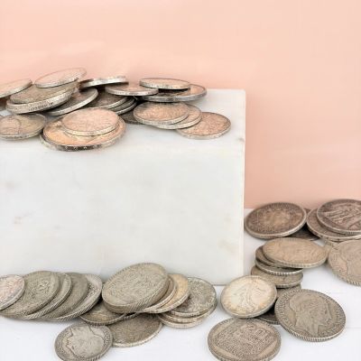 a pile of coins sitting on top of a marble block
