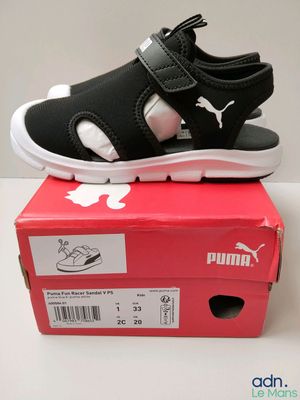 puma black and white sandals on top of a red box