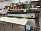 stainless steel counter top in a commercial kitchen with a lot of food on it
