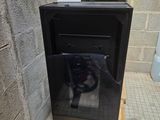 a black stove sitting on a pallet in a bathroom