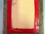 a red picture frame with a piece of paper on top of it