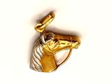 a gold horse head on a gold ring on a white background