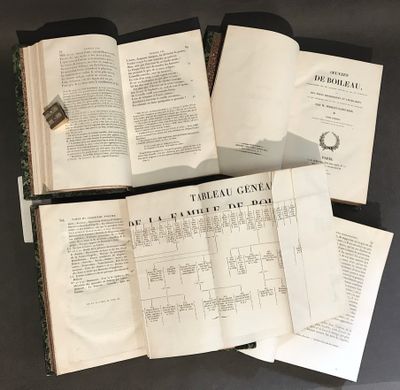 trois livres ouverts posés les uns sur les autres sur une table