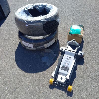 un skateboard posé par terre à côté d'un pneu
