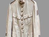 an old military jacket hanging on a hanger on a wall