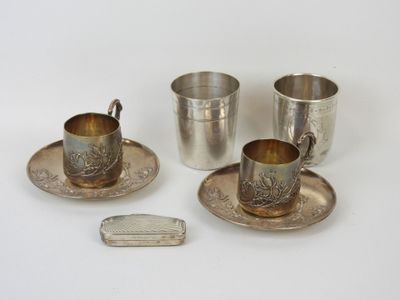 trois tasses et soucoupes plaquées argent posées sur une surface blanche