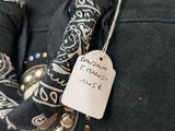 a black purse with a black scarf and a tag on it